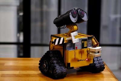 棕色木桌上的黄色和黑色Wall-E玩具